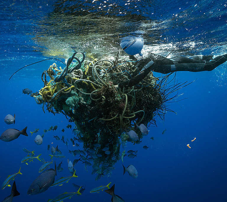 Ein Taucher befestigt einen GPS-Tracker an Geisterfischernetzen im Great Pacific Garbage Patch. Die Boje sendet die Position der Netze, während sie sich um den Wirbel bewegen, und verbessert so unser Verständnis der Strömungen und der Ansammlung von Müll im Wirbel. Die Besatzung des Greenpeace-Schiffes MY Arctic Sunrise dokumentiert auf ihrer Reise in den Great Pacific Garbage Patch Plastik und anderen Meeresmüll. Der Great Pacific Garbage Patch ist eine suppige Mischung aus Plastik und Mikroplastik, mittlerweile doppelt so groß wie Texas, mitten im Nordpazifik.